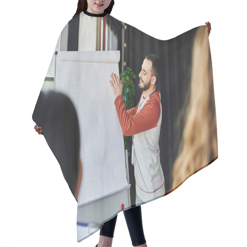 Personality  Young And Bearded Medical Instructor Adjusting Paper On Flip Chart During First Aid Seminar In Training Room Near Participants On Blurred Foreground, Emergency Situations Response Concept Hair Cutting Cape