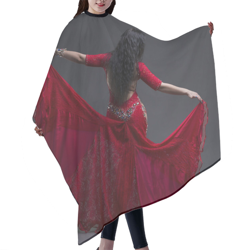 Personality  Young Beautiful Exotic Eastern Women Performs Belly Dance In Ethnic Red Dress With Open Back On Gray Background Hair Cutting Cape