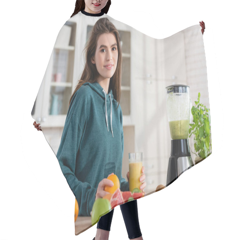 Personality  Smiling Woman Holding Glass Of Smoothie Near Fresh Fruits And Blender In Kitchen Hair Cutting Cape