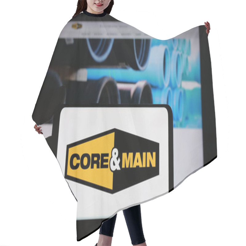 Personality  Stuttgart, Germany - 10-18-2024: Person Holding Cellphone With Logo Of US Distribution Company Core Main Inc. On Screen In Front Of Business Webpage. Focus On Phone Display. Hair Cutting Cape