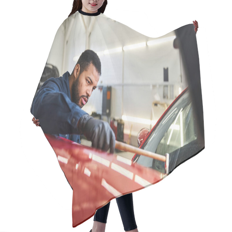 Personality  Young Man Meticulously Repairs A Red Car While Focused On His Task In A Garage Setting. Hair Cutting Cape