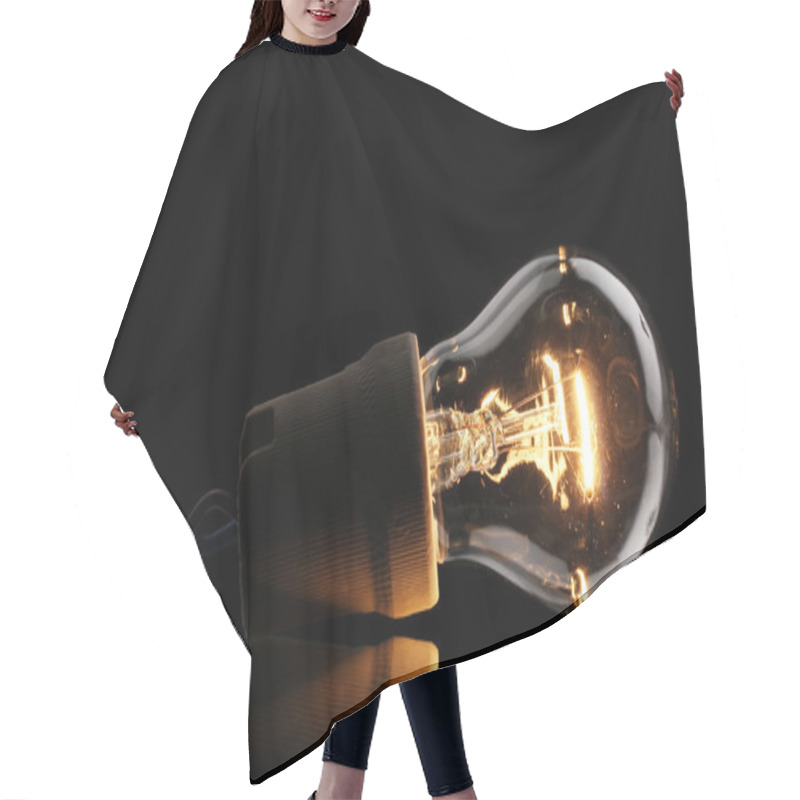 Personality  A Lit Light Bulb On Black Background Hair Cutting Cape