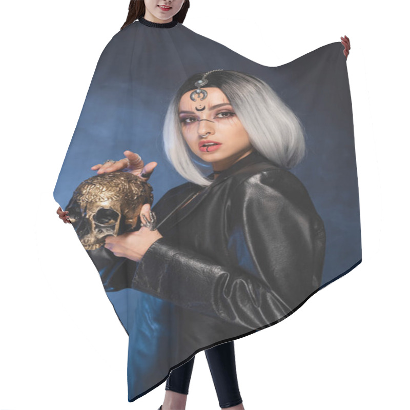 Personality  Ash Blonde Woman In Halloween Makeup And Leather Jacket Holding Golden Skull On Black Background With Blue Smoke Hair Cutting Cape