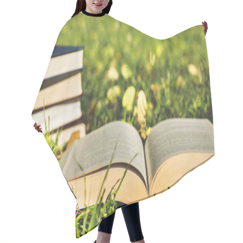 Personality  Open Book On The Grass With Pile Of Closed Books  Hair Cutting Cape