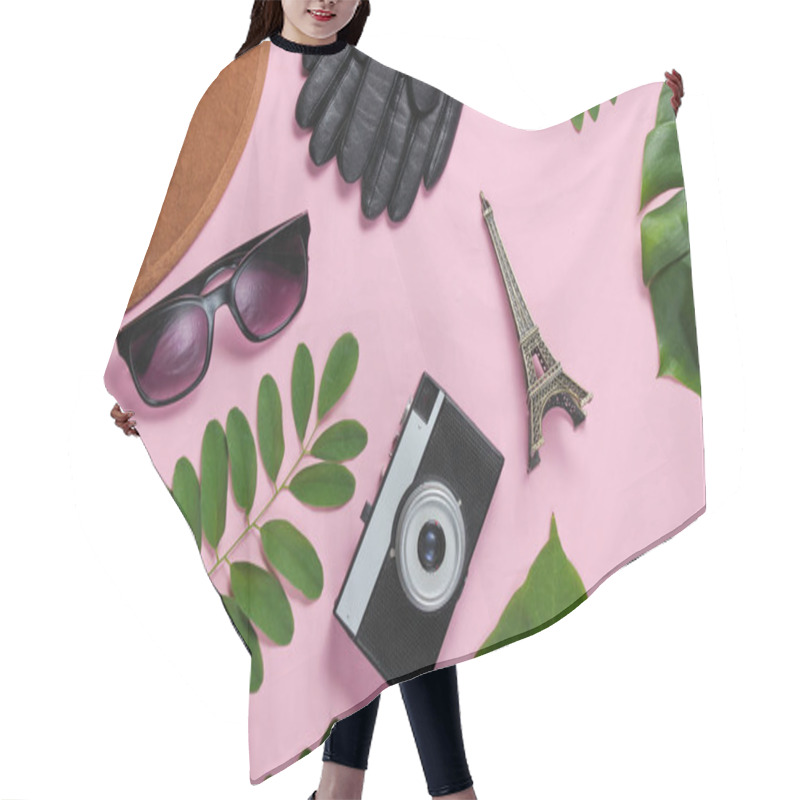 Personality  Jorney To Paris. Women's Accessories, Retro Camera, Figurine Of The Eiffel Tower On Pink Pastel Background With Green Leaves. Top View Hair Cutting Cape