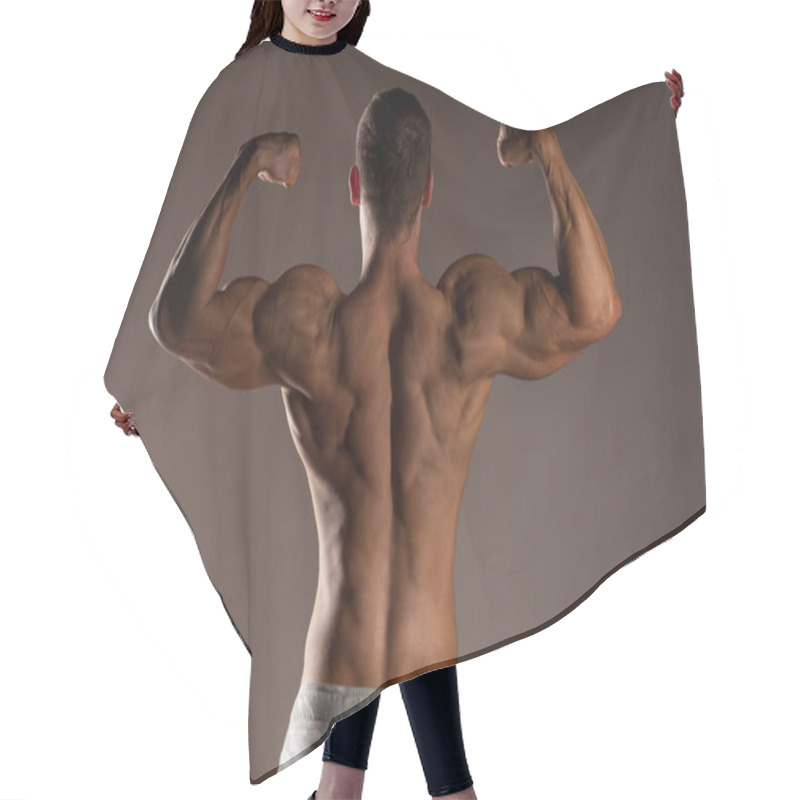 Personality  Rear View Of The Half-naked Handsome And Muscular Young Man Posing On A Gray Background Hair Cutting Cape