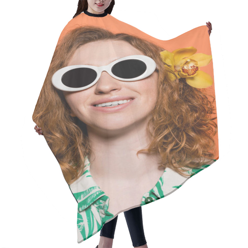 Personality  Portrait Of Young Cheerful And Redhead Woman With Orchid Flower In Hair Wearing Sunglasses And Standing On Orange Background, Summer Casual And Fashion Concept, Youth Culture Hair Cutting Cape