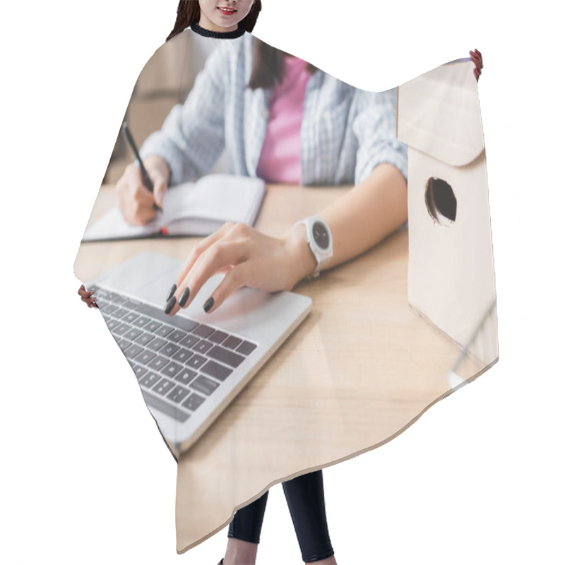 Personality  Cropped View Of Woman Using Laptop While Writing In Notebook At Desk With Carton Box On Blurred Background Hair Cutting Cape