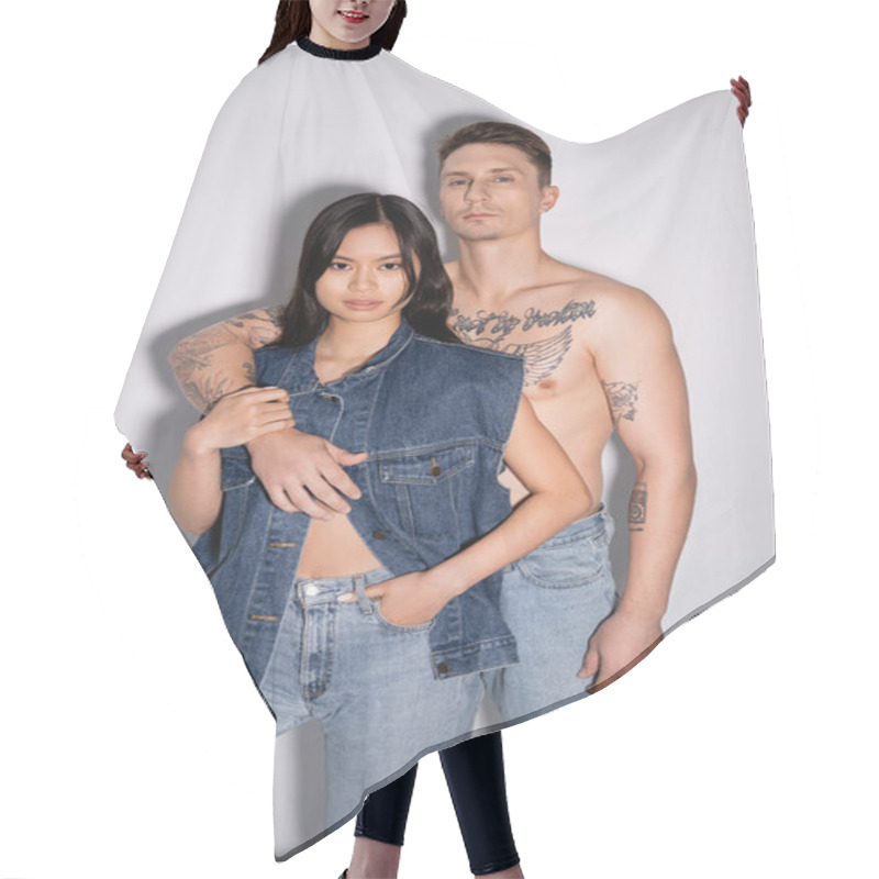 Personality  Shirtless Tattooed Man And Asian Woman In Denim Outfit Looking At Camera While Posing On Grey Background Hair Cutting Cape