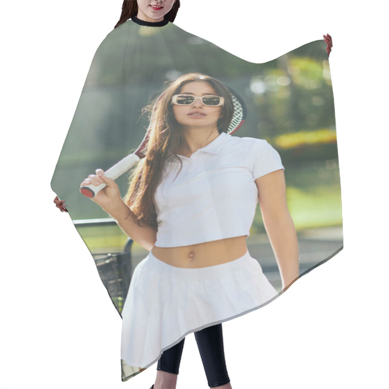 Personality  Sporty Young Woman With Long Brunette Hair Standing In White Outfit And Trendy Sunglasses While Holding Racket Near Ball Cart And Blurred Palm Trees In Miami, Sunny Day, Tennis Court  Hair Cutting Cape