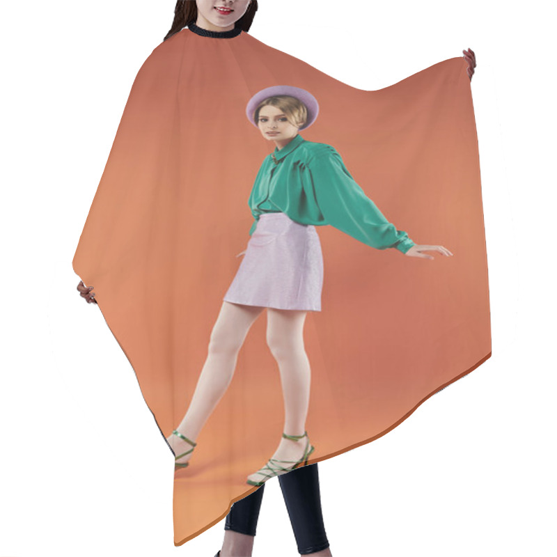 Personality  A Stylish Woman In A Green Blouse And Lavender Skirt Poses Playfully In A Vibrant Orange Studio. Hair Cutting Cape