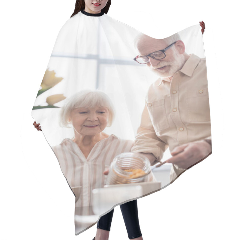 Personality  Selective Focus Of Smiling Elderly Woman Looking At Husband Pouring Cereals In Bowl Near Coffee  Hair Cutting Cape