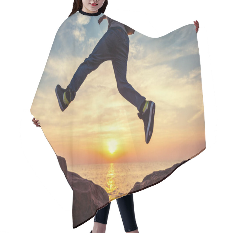 Personality  Young Brave Man With Backpack Jumping Over The Rocks Near The Sea In Sunset Hair Cutting Cape