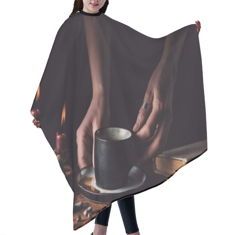 Personality  Cropped Shot Of Woman Holding Cup Of Coffee At Wooden Table With Chocolate, Truffles, Coffee Grains, Candles And Book On Black Background  Hair Cutting Cape