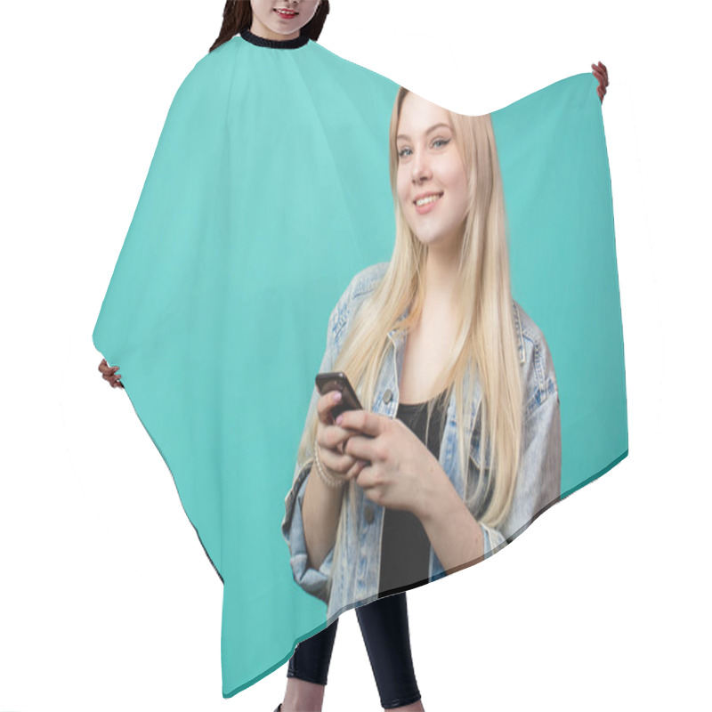 Personality  Cheerful Young Caucasian Female Using Smartphone On Blue Hair Cutting Cape