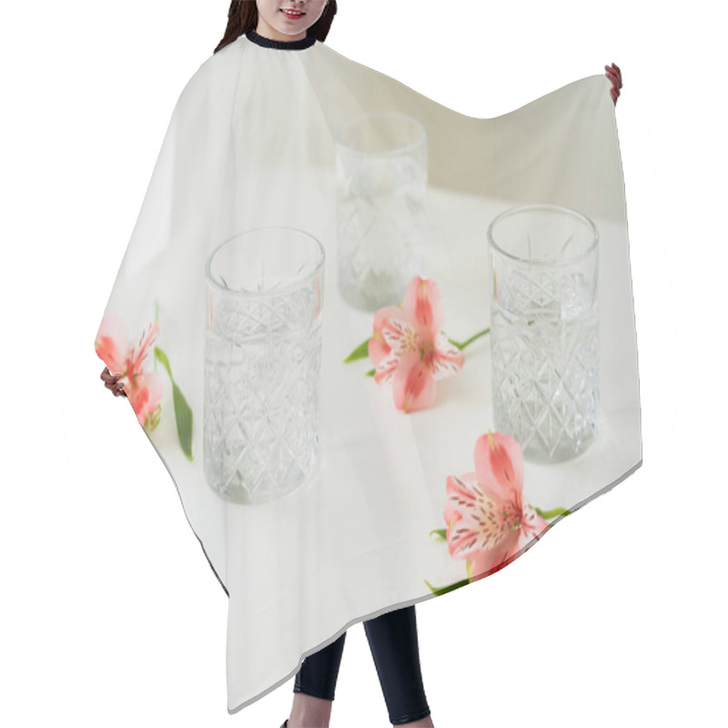 Personality  Crystal Glasses With Water Near Pink Flowers On White Surface And Grey Background Hair Cutting Cape