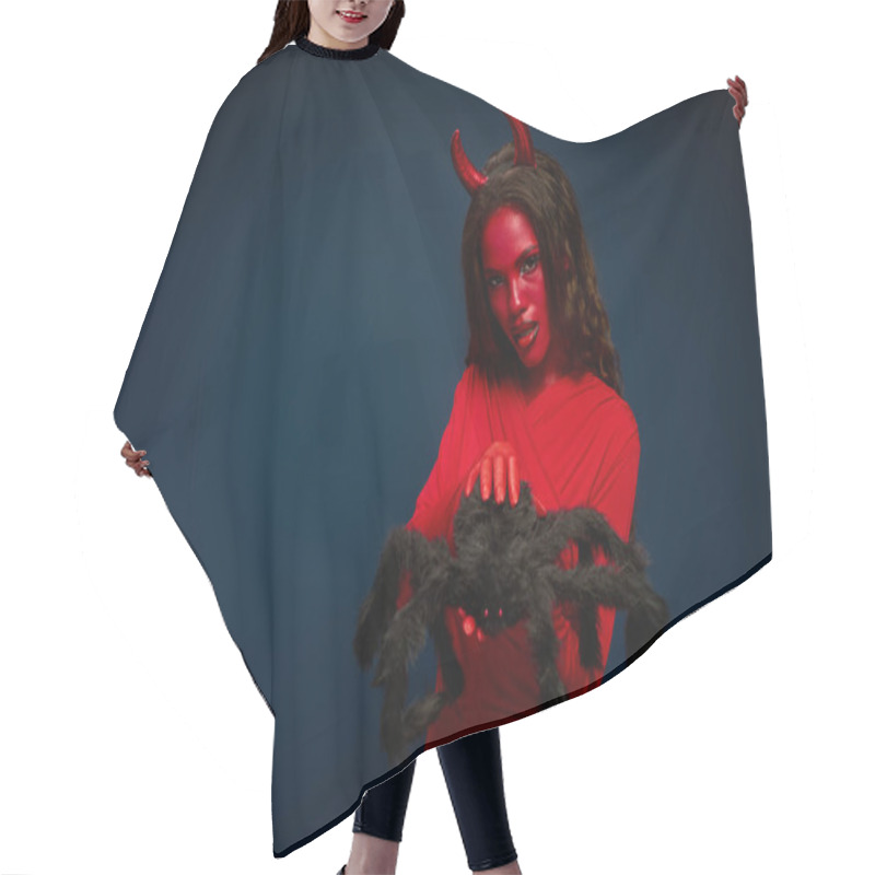 Personality  A Captivating Woman Dressed As A Devil Holds A Giant Spider, Embodying Halloween Spirit. Hair Cutting Cape