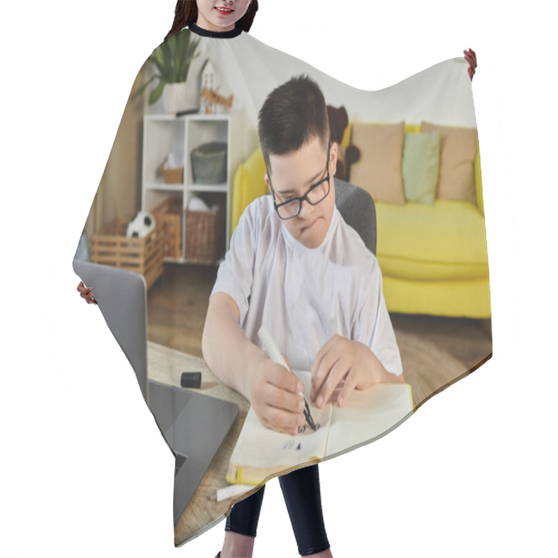 Personality  A Young Boy With Down Syndrome Sits At A Table In His Home, Intently Focused On His Work. Hair Cutting Cape