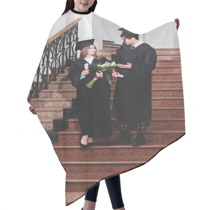 Personality  Happy Man In Graduation Cap Gesturing While Talking With Attractive Girl While Holding Diploma  Hair Cutting Cape