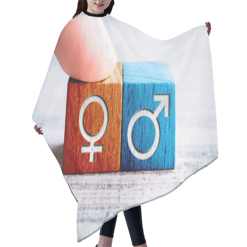 Personality  Gender Icon For Female On A Wooden Block Arranged By A Finger Next To The Male Sign On A Table Hair Cutting Cape