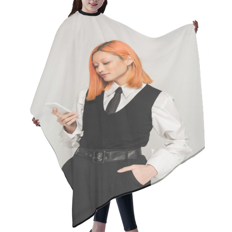 Personality  Young And Stylish Asian Woman With Dyed Red Hair Standing With Hand In Pocket And Looking At Smartphone On Grey Background, White Shirt, Black Vest, Tie And Pants, Business Casual Style, Gen Z Hair Cutting Cape