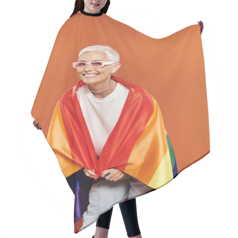 Personality  A Stylish Woman Wrapped In A Rainbow Flag Beams With Joy Against An Orange Backdrop. Hair Cutting Cape