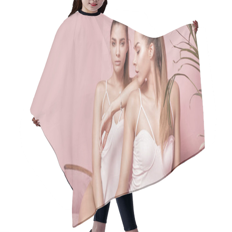 Personality  Beautiful Caucasian Twins Female Models On Pink Background. Hair Cutting Cape