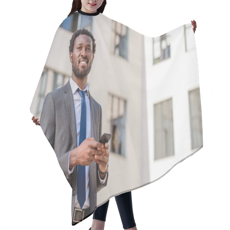 Personality  Cheerful African American Businessman Looking Away While Holding Smartphone Hair Cutting Cape