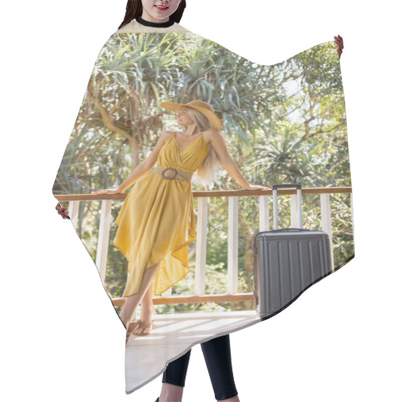 Personality  A Stylish Woman In A Yellow Dress And Sun Hat Leans Against A Balcony Railing With Her Suitcase, Surrounded By Lush Tropical Greenery. Perfect For Travel, Vacation, And Summer Fashion Concepts. Hair Cutting Cape