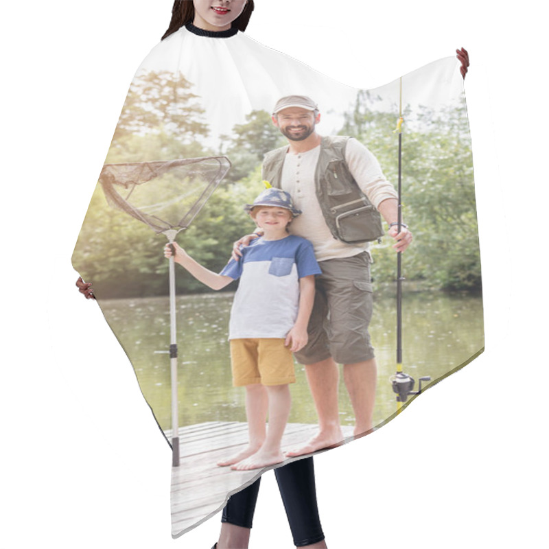 Personality  Full Length Portrait Of Smiling Father And Son Standing With Fishing Tackles On Pier Against Lake Hair Cutting Cape