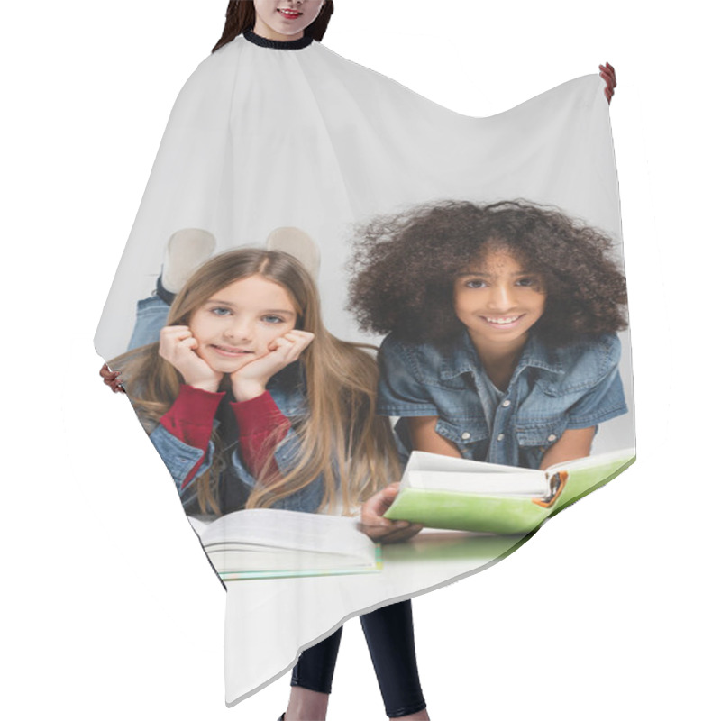 Personality  Happy Multicultural Schoolkids Smiling At Camera While Lying With Books On Grey Hair Cutting Cape