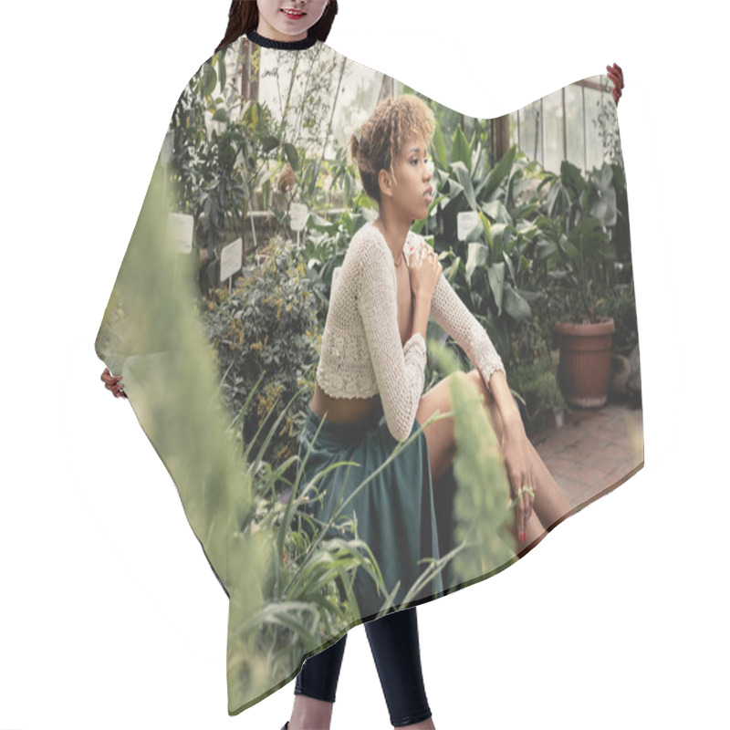 Personality  Young And Relaxed African American Woman In Summer Outfit And Knitted Top Sitting Near Green Plants In Blurred Indoor Garden At Background, Fashion-forward Lady In Midst Of Tropical Greenery Hair Cutting Cape