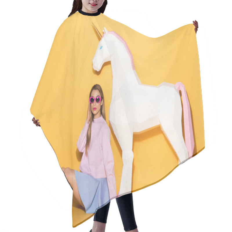 Personality  Decorative Unicorn And Stylish Asian Female Model In Sunglasses Sitting On Floor On Yellow Background  Hair Cutting Cape