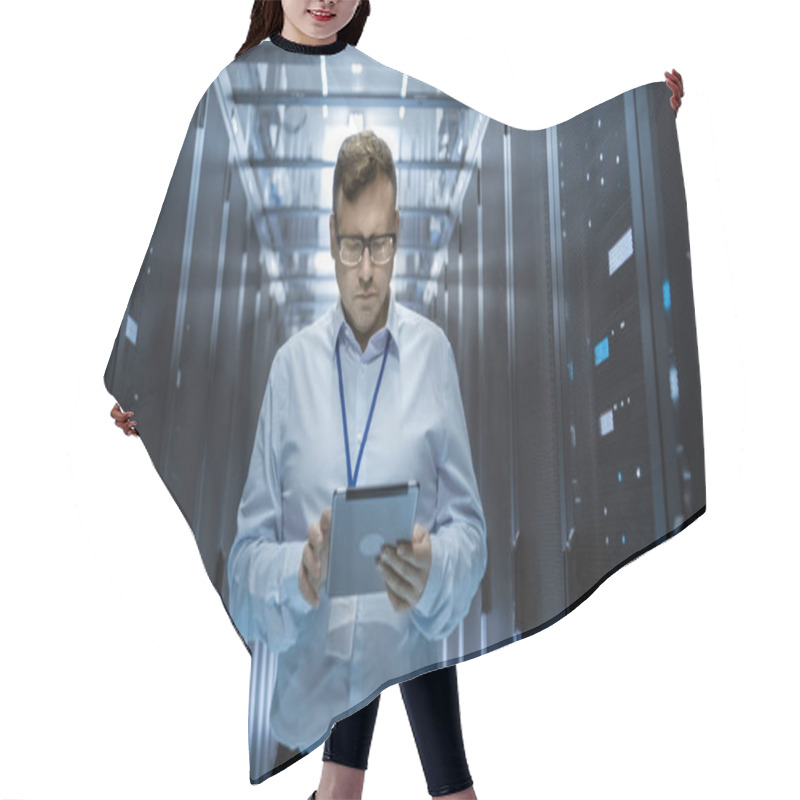 Personality  IT Technician Walks Through Rows Of Server Racks In Data Center. Simultaneously He Works On A Tablet Computer. Hair Cutting Cape