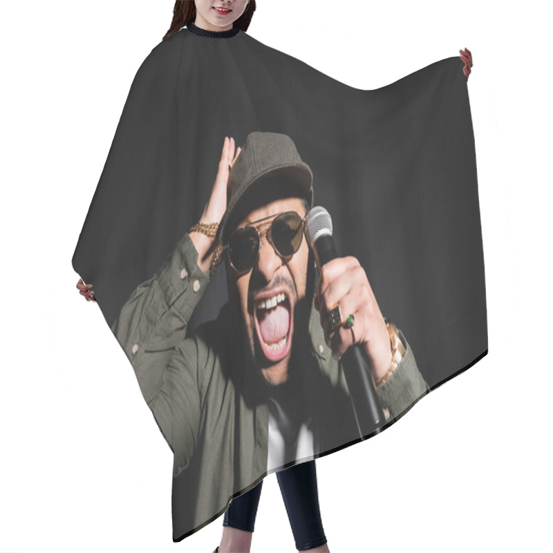 Personality  Emotional Middle East Hip Hop Performer In Sunglasses And Cap Screaming While Holding Microphone Isolated On Black Hair Cutting Cape