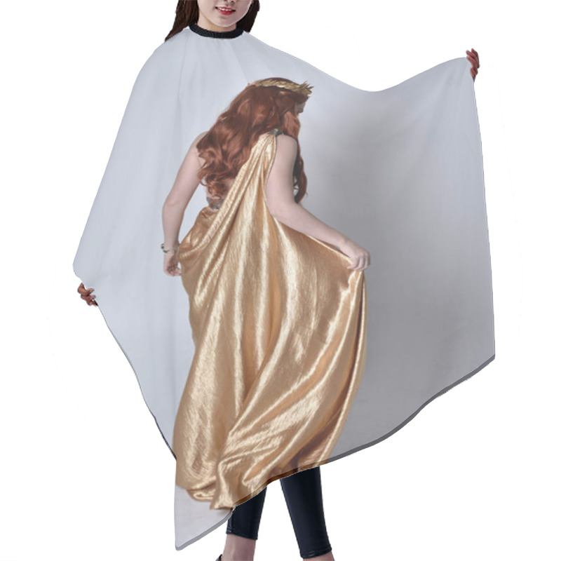 Personality  Full Length Portrait Of Girl With Red Hair Wearing Long Grecian Toga And Golden Wreath. Standing Pose With Back To The Camera,  Isolated Against A Grey Studio Background. Hair Cutting Cape