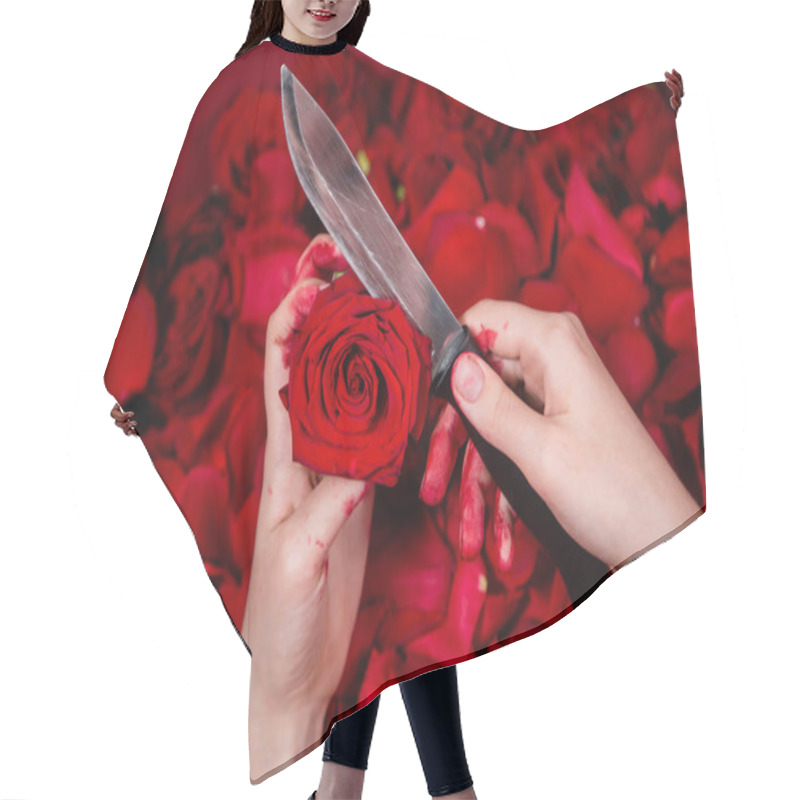 Personality  Close-up Of Hands In Blood Holding A Knife And A Rose Bud, Against A Background Of Roses And Petals. Hair Cutting Cape