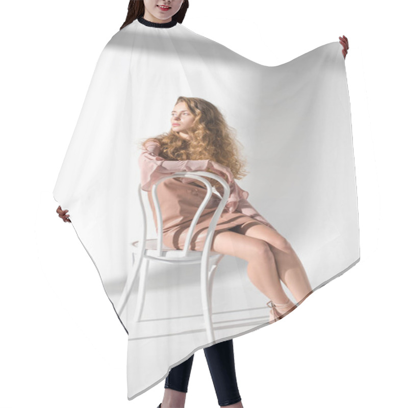 Personality  Fashionable Woman In Beige Dress And Curly Hair Sitting On White Chair Hair Cutting Cape