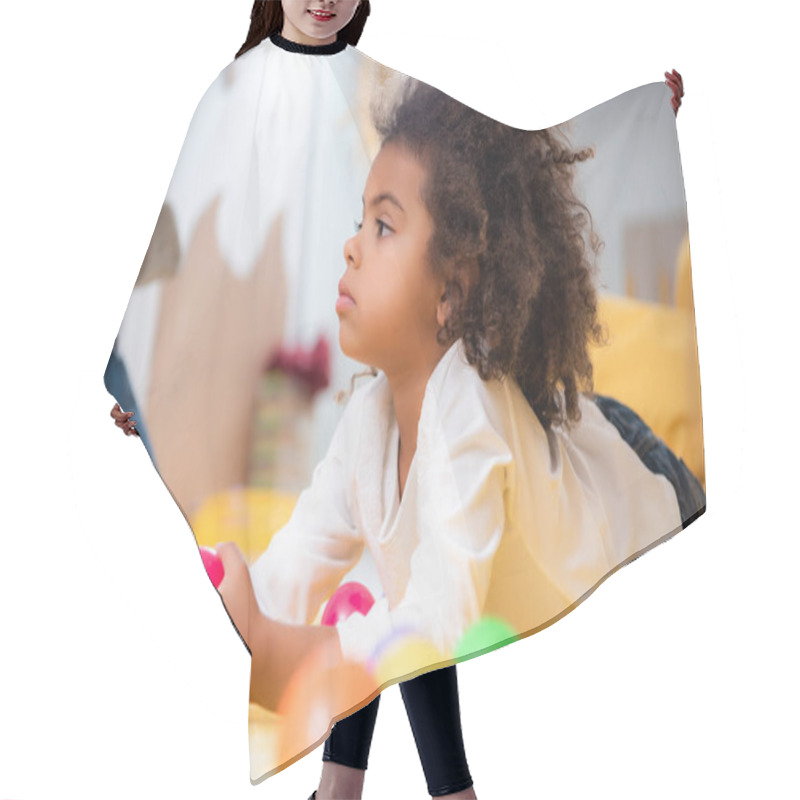 Personality  Side View Of Adorable African American Kid Lying On Carpet With Toys And Looking Away In Kindergarten Hair Cutting Cape