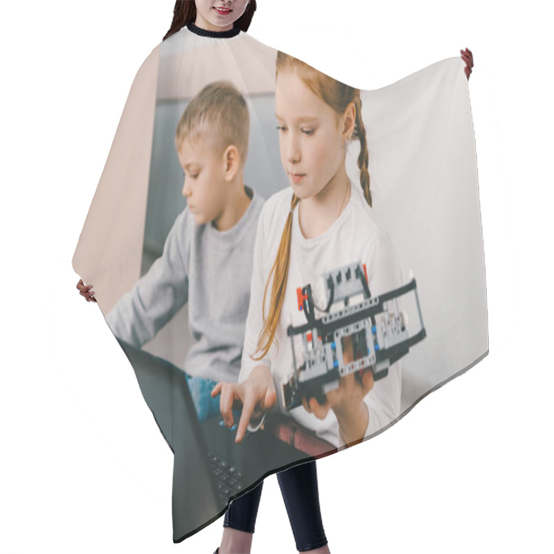 Personality  Teen Schoolgirl Programming Robot While Sitting On Floor With Kid Hair Cutting Cape