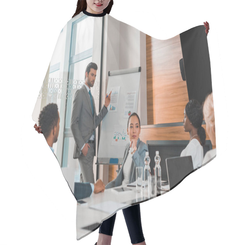 Personality  Handsome Businessman Pointing With Finger At Flipchart With Infographics While Multicultural Colleagues Sitting At Desk In Conference Hall Hair Cutting Cape