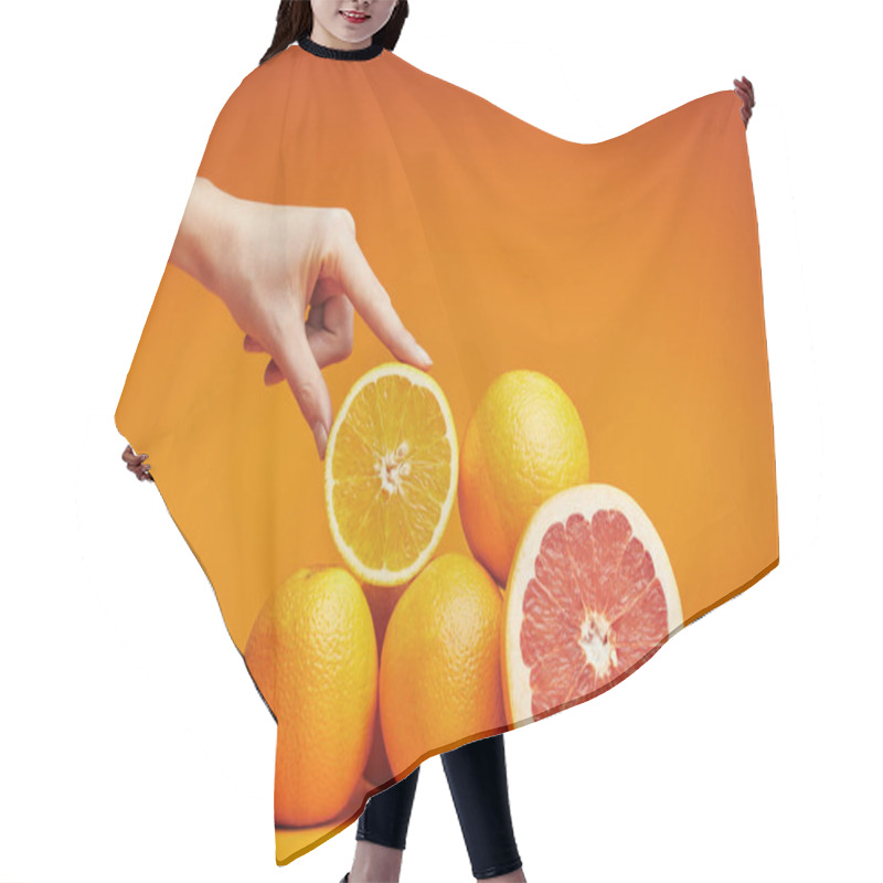 Personality  Cropped Shot Of Human Hand And Fresh Ripe Citrus Fruits On Orange Hair Cutting Cape