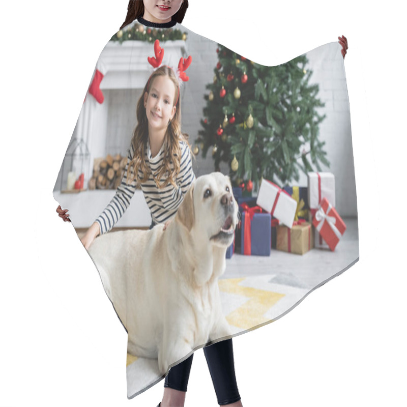 Personality  Girl With Christmas Headband Looking At Camera Near Labrador In Living Room  Hair Cutting Cape