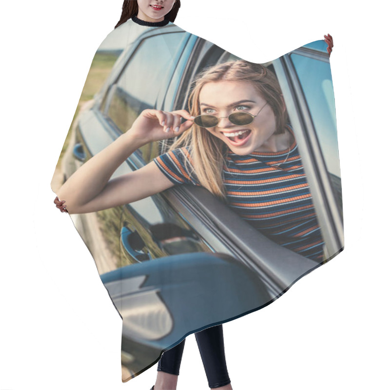 Personality  Front View Of Excited Young Woman Leaning Out From Car Window  Hair Cutting Cape