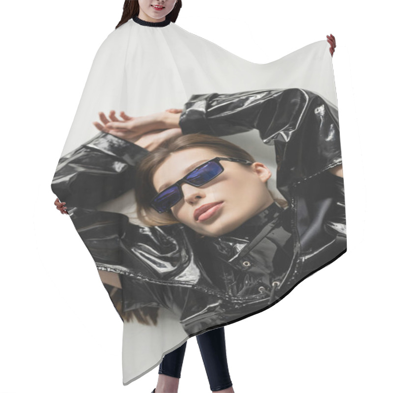 Personality  Top View Of Brunette Woman In Black Latex Jacket And Stylish Sunglasses Lying On Grey Hair Cutting Cape