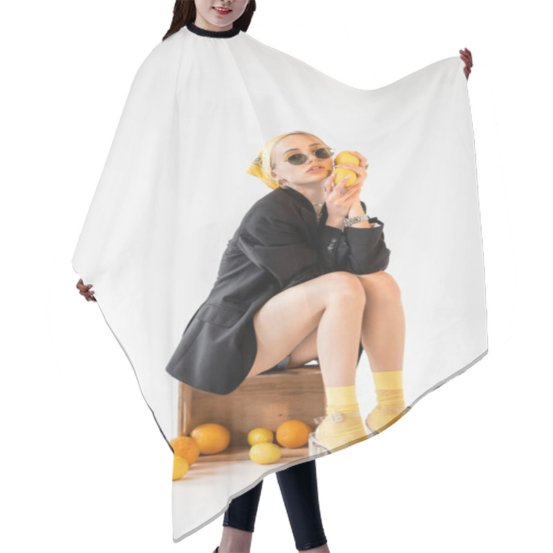 Personality  Fashionable Woman Posing On Wooden Box Near Scattered Citrus Fruits On White Background Hair Cutting Cape