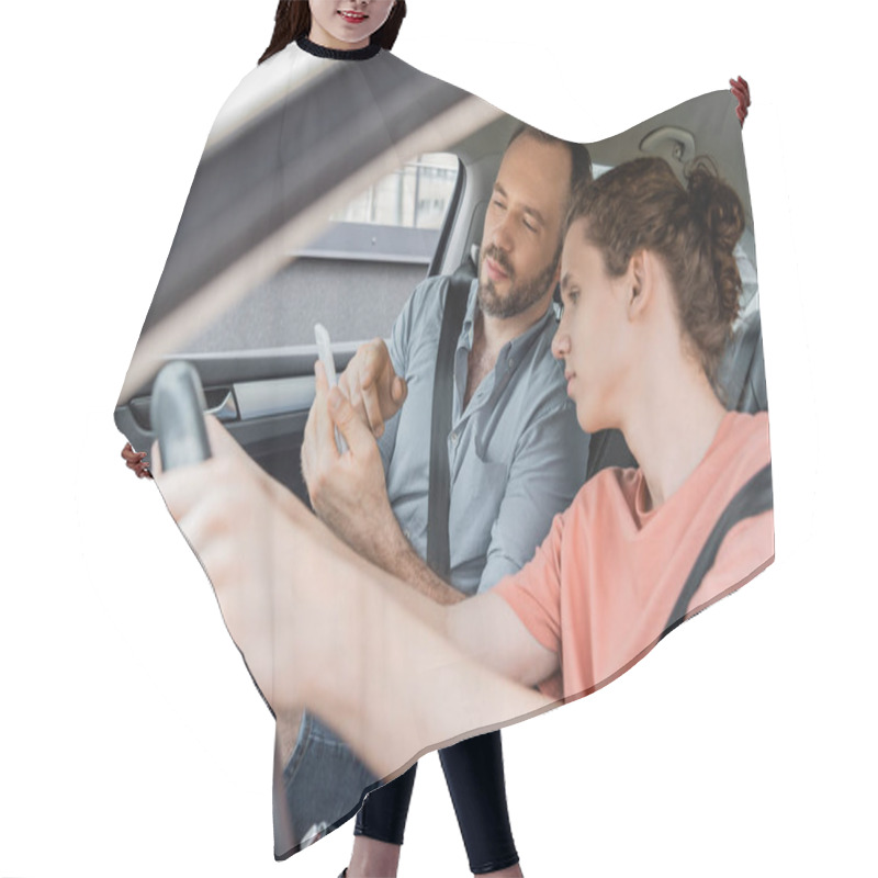 Personality  Bearded Father Pointing At Smartphone While Sitting Next To Teenage Son In Car  Hair Cutting Cape