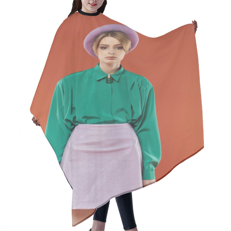 Personality  A Woman In A Lavender Mini-skirt And Green Shirt Poses Against An Orange Background. Hair Cutting Cape