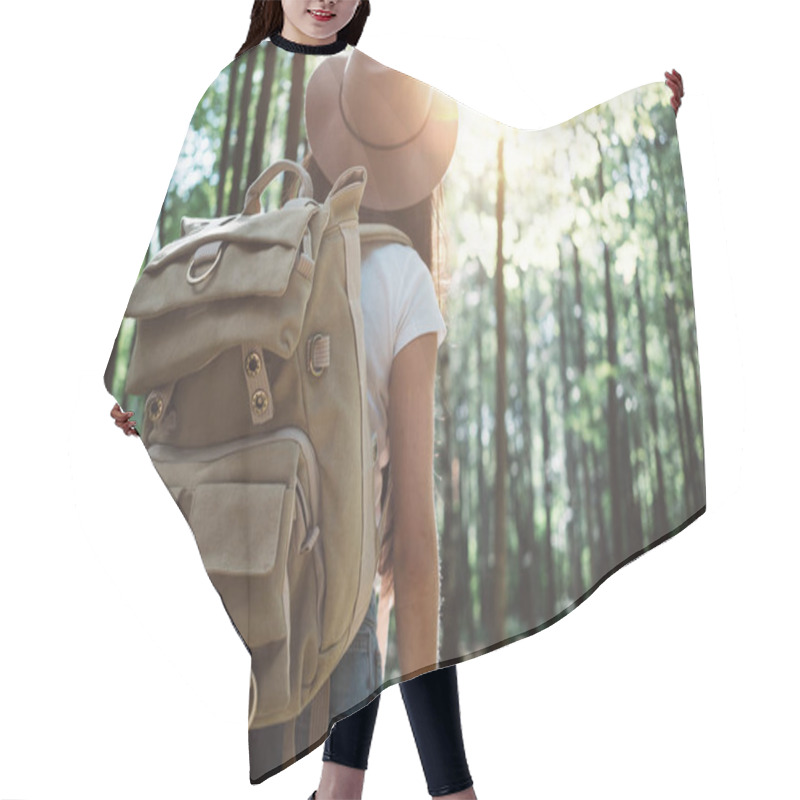 Personality  Handsome Traveler Woman With Backpack And Hat Standing In Forest. Young Hipster Girl Walking Among Trees On Sunset. Close-up Traveling Backpack Hair Cutting Cape