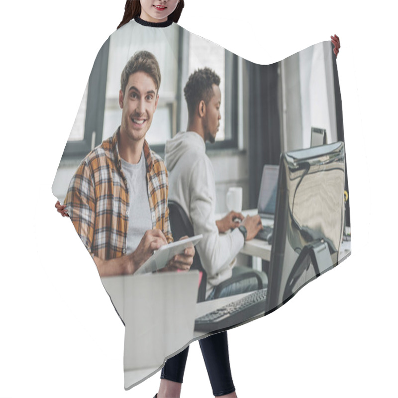 Personality  Cheerful Young Programmer Smiling At Camera While Sitting Near African American Colleague And Using Digital Tablet Hair Cutting Cape